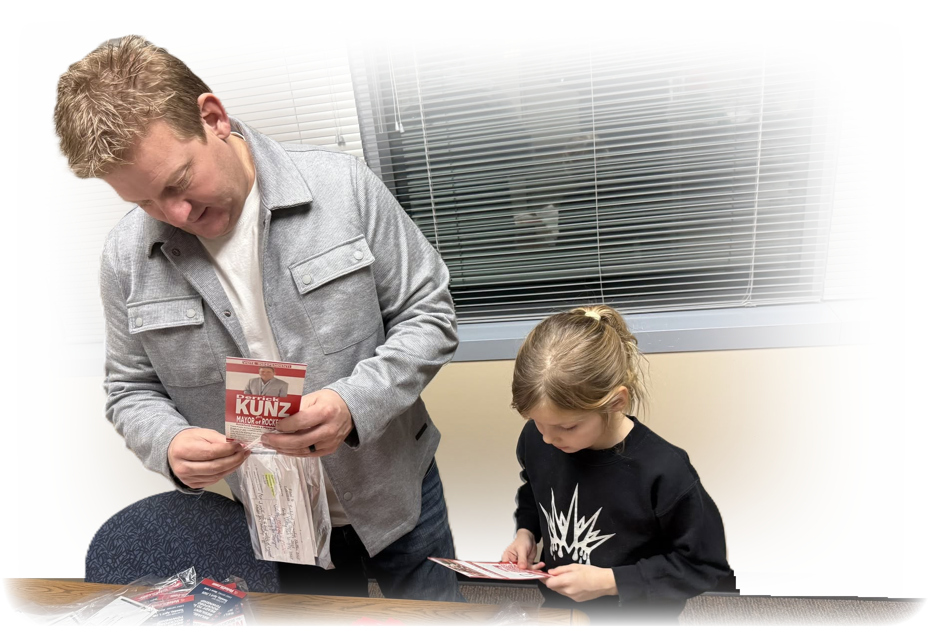 Derrick Kunz working on campaign materials with a young Rockford resident